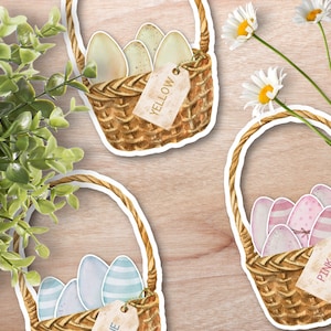 May include: Three wicker baskets filled with colorful Easter eggs. The baskets have tags that say "Yellow", "Pink", and "Blue".