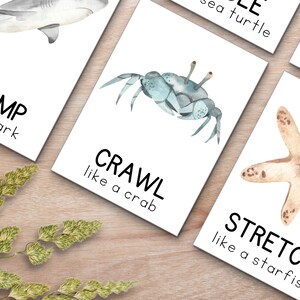 May include: Four white cards with black text and watercolor illustrations of a shark, crab, starfish, and sea turtle. The cards instruct the viewer to "chomp like a shark", "crawl like a crab", "stretch like a starfish", and "waddle like a sea turtle".