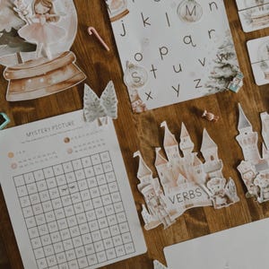 Peut inclure: Ensemble de jouets &eacute;ducatifs et de d&eacute;corations, comprenant des cartes d'alphabet, un jeu d'images myst&egrave;res et des d&eacute;coupes de ch&acirc;teaux. Les articles sont dans des couleurs pastel douces, avec un fond en bois. Th&egrave;me de No&euml;l.