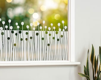 May include: A white window with a frosted glass design featuring a row of black stylized grass with rounded tops. The window is framed in white and is set against a white wall.