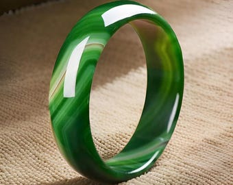May include: A green jade bangle with white and light green stripes. The bangle is smooth and polished.