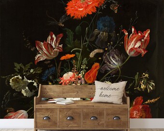 Può includere: Un dipinto vintage di natura morta con un mazzo di fiori rossi, bianchi e arancioni su uno sfondo scuro. I fiori sono disposti in un vaso e circondati da foglie verdi. Il dipinto è incorniciato e appeso a un muro. Una panca di legno con un cuscino su cui è scritto "benvenuti a casa" si trova in primo piano.
