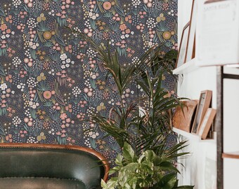 May include: A dark blue wallpaper with a floral pattern featuring pink, green, and yellow flowers and leaves. A green leather couch and a potted plant are in the foreground.