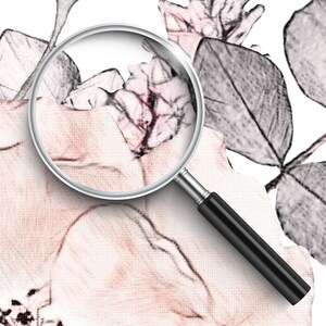 Op de afbeelding: Een vergrootglas is geplaatst over een delicaat bloemenpatroon, waardoor ingewikkelde details van roze en witte bloemen en grijze bladeren zichtbaar worden. De achtergrond is een wit canvas.