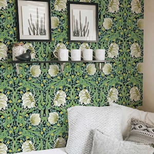 May include: A bedroom with a bed, pillows, and a shelf with mugs. The wall is covered in a dark green and white floral wallpaper with a repeating pattern.