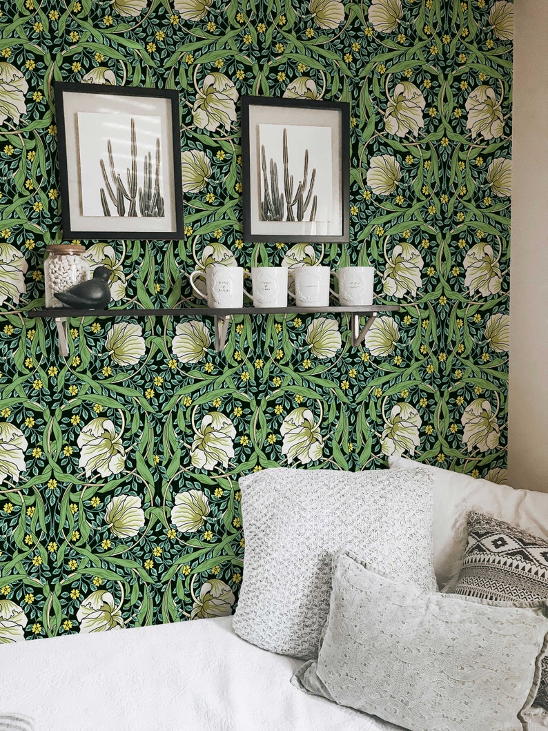 May include: A bedroom with a bed, pillows, and a shelf with mugs. The wall is covered in a dark green and white floral wallpaper with a repeating pattern.