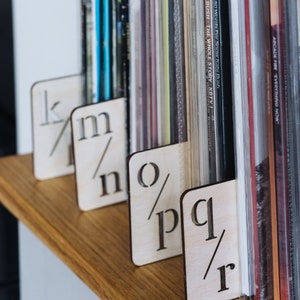 Puede incluir: Divisores de madera para una estanter&iacute;a de discos, etiquetados con letras de la k a la r.