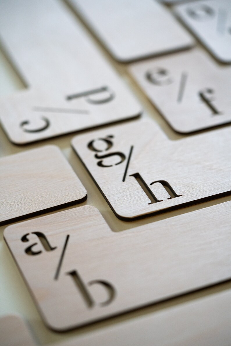 Puede incluir: Bloques de alfabeto de madera con letras recortadas, mostrando las letras a/b, c/d, e/f, g/h. Los bloques est&aacute;n dispuestos en forma escalonada.