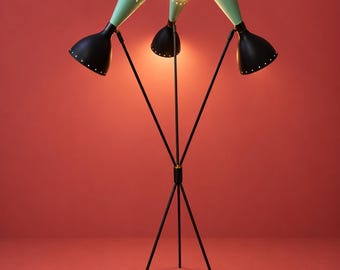 May include: A three-armed floor lamp with a thin black metal tripod base and three adjustable heads. Each head features a matte black lower section and a light green upper cone with small perforated holes along the rim, emitting light.