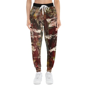 Może przedstawiać: Damskie spodnie dresowe z kolorowym abstrakcyjnym nadrukiem. Spodnie dresowe mają sznurek w pasie i luźny krój.