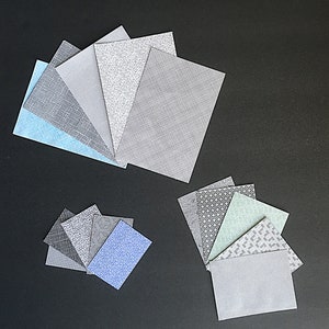 May include: Assortment of fabric swatches in various colors and patterns, including blue, gray, and green. The swatches are arranged in two groups, with one group of seven swatches and another group of six swatches.
