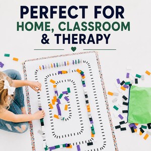 May include: A white rectangular play mat with a black dashed track pattern, featuring colorful dominoes in purple, orange, green, white, and black. The text PERFECT FOR HOME, CLASSROOM & THERAPY is printed above the mat with a green heart icon.