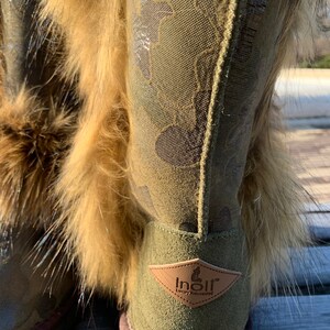 Peut inclure: Bottines en daim vert avec un motif camouflage et une bordure en fausse fourrure. Les bottes ont une &eacute;tiquette en cuir marron avec le texte "Inolir Luxury Reinvented".