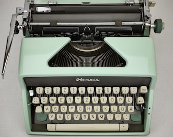Máquina de escribir Olympia SM7 de color menta con tipografía Congress Elite, ideal para el Día de la Madre, el Día del Padre o como regalo de graduación.