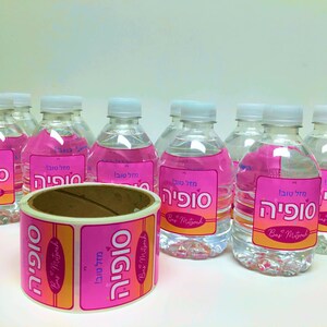 May include: A roll of pink and orange stickers with the Hebrew text "Mazal Tov Sophia" and the English text "Bar Mitzvah" on them. The stickers are designed for water bottles.