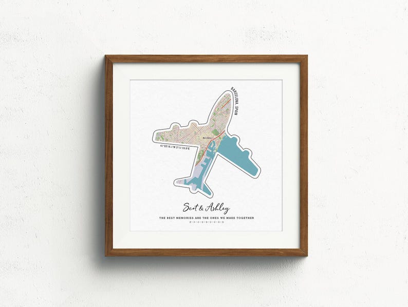May include: A framed print with a map of Barcelona, Spain, shaped like an airplane. The text "Scot & Ashley" and "The best memories are the ones we make together" is printed below the map.