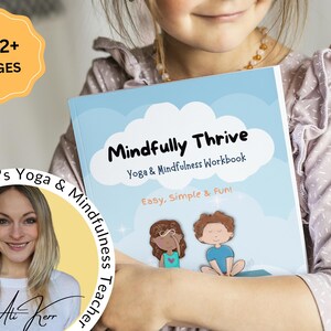 K&ouml;nnte beinhalten: Ein junges M&auml;dchen h&auml;lt ein blaues und wei&szlig;es Buch mit dem Titel "Mindfully Thrive: Yoga & Mindfulness Workbook". Der Buchumschlag zeigt eine Comic-Illustration von zwei Kindern, die Yoga-Posen einnehmen. Das Buch wird als "Einfach, Einfach & Spa&szlig;!" beschrieben und hat &uuml;ber 102 Seiten.