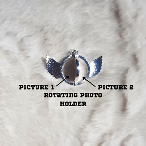 Puede incluir: Portafotos giratorio plateado con alas. El portafotos est&aacute; dise&ntilde;ado para sostener una foto o imagen peque&ntilde;a. Las alas est&aacute;n a cada lado del portafotos. El portafotos est&aacute; etiquetado como "Picture 1" y "Picture 2".