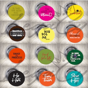 Puede incluir: Doce botones redondos con varios colores y diseños. Los botones presentan texto como "In need of Vitamin D", "Sunkissed", "You got me", "Phenomenal Woman", "Trust the Process", "One of God's Gifts", "Be sure to me so I know it's real", "He Him", "They Them", y "She Her".