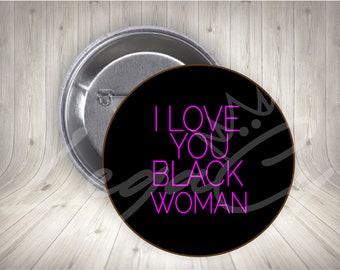 Pode incluir: Um botão preto com borda branca e o texto "I LOVE YOU BLACK WOMAN" em letras de néon rosa.