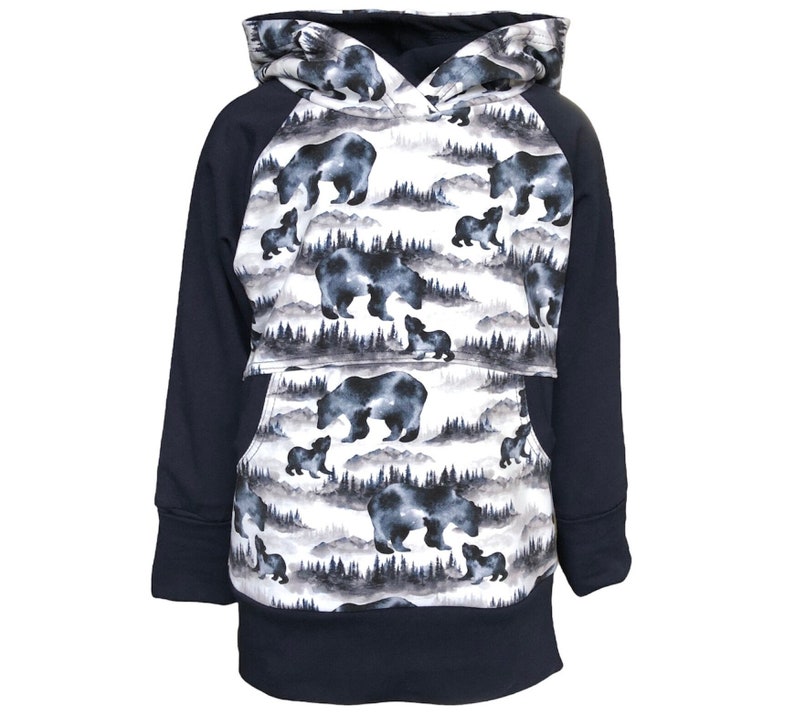 May include: A navy blue hooded sweatshirt with a white and gray pattern of bears and trees. The sweatshirt has a kangaroo pocket and raglan sleeves.