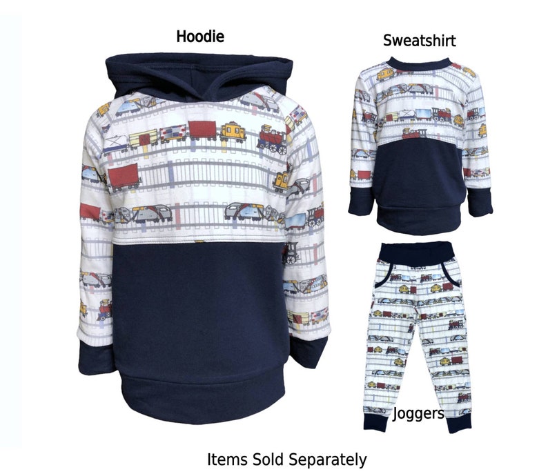 May include: A set of children's clothing featuring a navy blue hoodie, sweatshirt, and joggers with a white and blue train pattern. The text "Hoodie", "Sweatshirt", and "Joggers" are printed on the image. The text "Items Sold Separately" is printed at the bottom of the image.