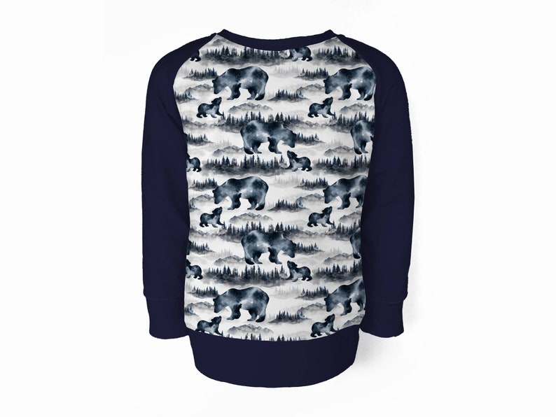 May include: A navy blue sweatshirt with long sleeves and a white front panel featuring a repeating pattern of watercolor bears and trees. The sleeves are a solid navy blue.