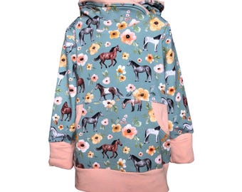 May include: A teal blue hooded sweatshirt with a pink trim and a pattern of horses and flowers.