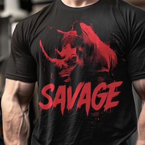 Peut inclure: T-shirt noir avec un dessin de rhinocéros rouge et le mot "SAVAGE" en rouge. Le design du rhinocéros est artistique et détaillé. Le t-shirt est de style col rond, idéal pour un look décontracté.