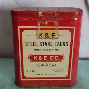 Vintage K and E metal box of steel stake tacks.