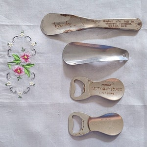 May include: Four vintage metal objects: two shoe horns, one with the text "HAYWARD BROS. SHOE CO. ST. LOUIS FOOTWEAR. OMAHA, NEB." and the other without text, and two bottle openers, one with the text "HOTELS MAYFAIR-TENNOX SAINT LOUIS" and the other with the text "HOTELS MAYFAIR-TENNOX SAINT LOUIS".