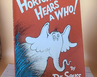 May include: A red book cover with the title "Horton Hears a Who!" in white text. The cover features an illustration of Horton the elephant, who is white with blue and black details. The book is by Dr. Seuss.