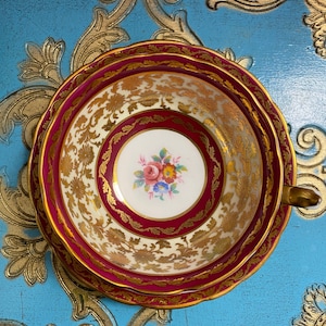 Double warrant paragon red and gold tea cup and saucer with floral centre