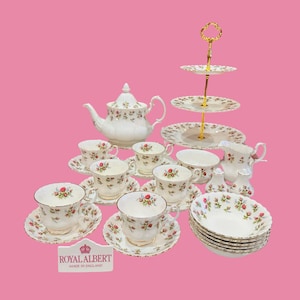 Puede incluir: Un juego de té Royal Albert completo con un estampado floral. El juego incluye una tetera, tazas, platillos, cuencos, una fuente de servicio escalonada y otras piezas para servir. El juego es blanco con un diseño floral rosa y ribetes dorados.