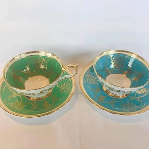 Pair of matching wide mouth aynsley green and blue tea cup and saucer with grapevines and gold details
