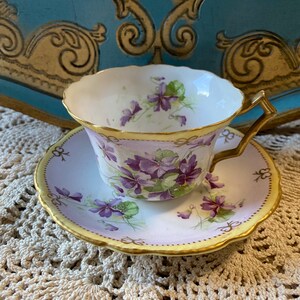As is unique unmarked European purple violets tea cup and saucer with bow tie pattern and unique shape, gold handle antique china, tea party