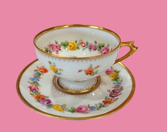 Juego de taza y platillo de porcelana de Dresde, Alemania, pintado a mano, con base, de la década de 1940, con motivos florales y detalles dorados.