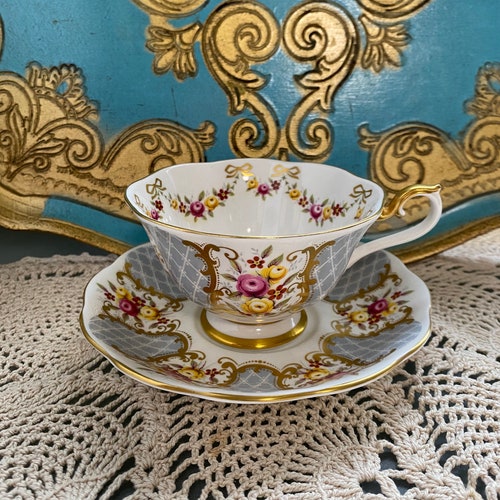 Rare royal Albert Marie louise Gray and shops gold tea cup and saucer, Avon shape, gold bow tie Garland, pink roses