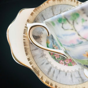 Pu&ograve; includere: Un set da t&egrave; bianco con una tazza e un piattino con un motivo floreale e un bordo dorato. Il piattino ha un bordo smerlato.