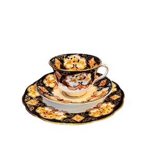 Puede incluir: Un juego de té de tres piezas con un patrón floral azul y dorado. La taza, el platillo y el plato están decorados con detalles intrincados.