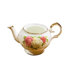 Puede incluir: Tetera blanca con ribete dorado y un diseño floral con rosas rosas y blancas.