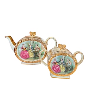 Może przedstawiać: Zestaw porcelanowy do herbaty składający się z czajnika i dzbanuszka z pozłacanymi akcentami. Zestaw zdobi kwiatowy wzór i scena z trzema kobietami w ogrodzie.
