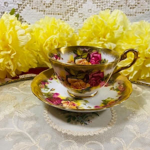 Goldene Teetasse mit Untertasse von Royal Teetasse mit Untertasse von Royal Golden Rose mit schwerem Goldrand und großen rosa Rosen