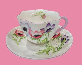 Plato vintage Shelley “Flor del Viento” n.° 14032. Forma delicada y asa rosa/morada, porcelana fina inglesa. En perfecto estado.