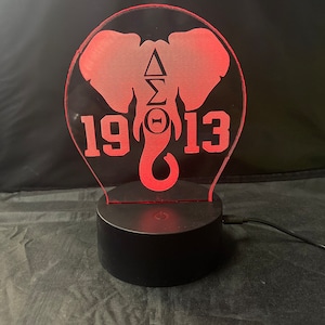 May include: Red LED night light shaped like an elephant with the Greek letters Delta Sigma Theta and the year 1913.