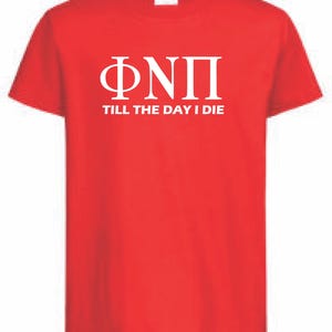 Könnte beinhalten: Ein rotes T-Shirt mit weißen griechischen Buchstaben und dem Text "TILL THE DAY I DIE" darunter. Das T-Shirt hat einen Rundhalsausschnitt und besteht wahrscheinlich aus Baumwolle oder einem ähnlichen Material. Das Design ist mittig auf der Vorderseite platziert.