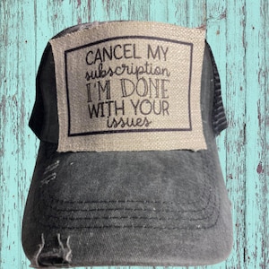 May include: Black trucker hat with a brown patch that says "CANCEL MY subscription I'M DONE WITH YOUR issues".
