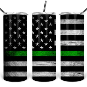 May include: Three stainless steel tumblers with a black and white American flag design and a green stripe. The tumblers have a distressed look.