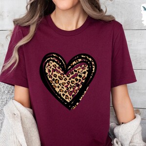 Puede incluir: Una camiseta de color granate con un gr&aacute;fico de coraz&oacute;n de contorno negro. El coraz&oacute;n est&aacute; relleno con un estampado de leopardo.