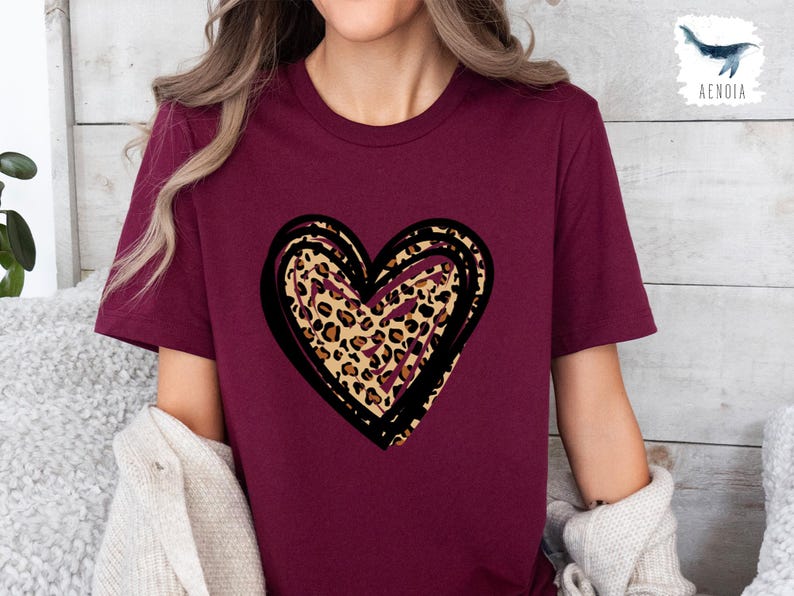 Puede incluir: Una camiseta de color granate con un gr&aacute;fico de coraz&oacute;n de contorno negro. El coraz&oacute;n est&aacute; relleno con un estampado de leopardo.